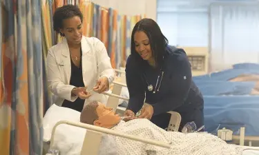 Nurse Teacher Who Went From BSN to Nurse Educator Instructing Student to Take Blood Pressure