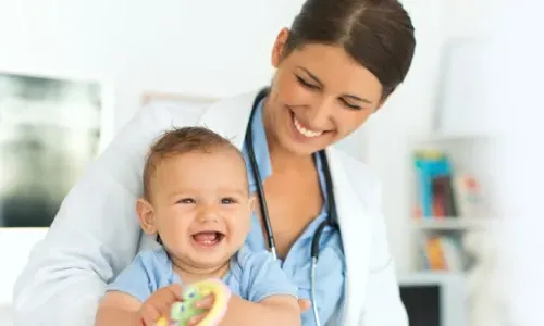 Pediatric Nurse Practitioner Smiling with Infant Patient in Appointment